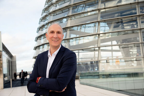 MdB Christoph Schmid steht auf der Dachterrasse des Deutschen Bundestages vor der Reichstagskuppel