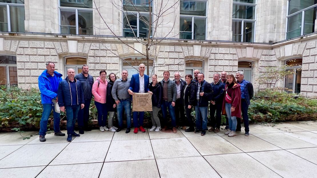 MdB Christoph Schmid mit dem Gemeinderat Alerheim bei Ausschütten der Erde aus dem Wahlkreis beim Kunstwerk Der Bevölkerung