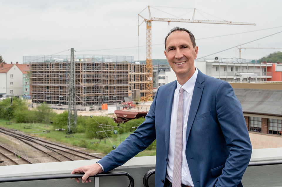 Christoph Schmid steht vor einer Baustelle